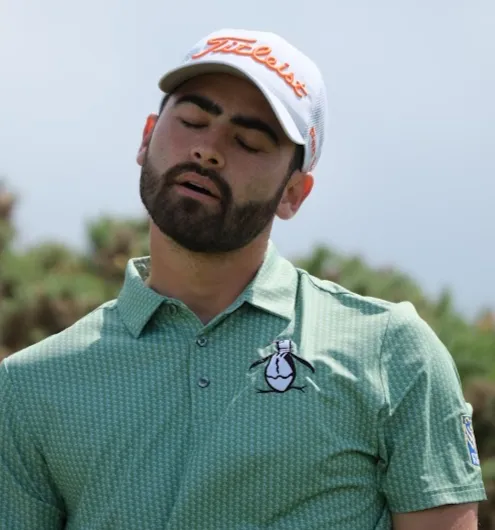 A golfer with his eyes closed, gathering himself between shots.